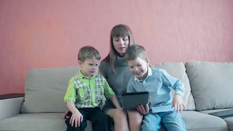 mother and two sons playing with tablet