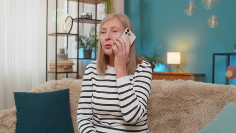 mature woman frustrated arguing on phone expressing irritation annoying advertising calls at home