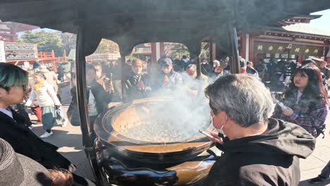 visitors partake in incense smoke ritual for blessings