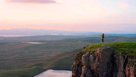 woman on a cliff at sunrise