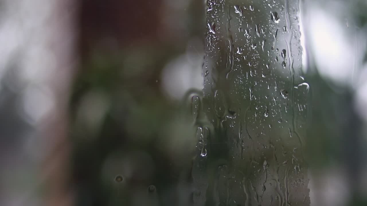 Rainy day, drops on window glass seen from inside the house looking out