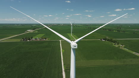 approaching on wind turbines in the corn fields of iowa, united states