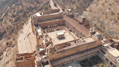 wide view of amber fort interior courtyard and garden in jaipur, rajasthan, india - aerial orbit tracking shot