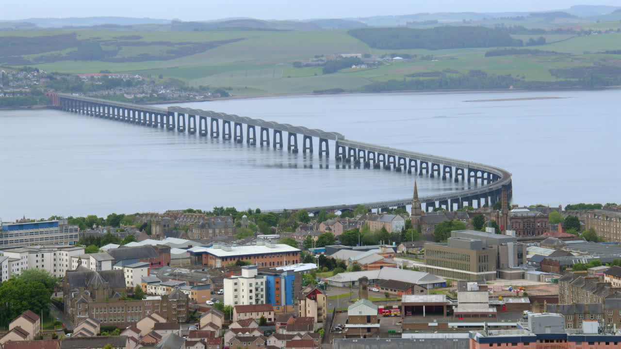 Wide panning shot of the Tay rail bridge over the river Tay at Dundee, taken from law hill