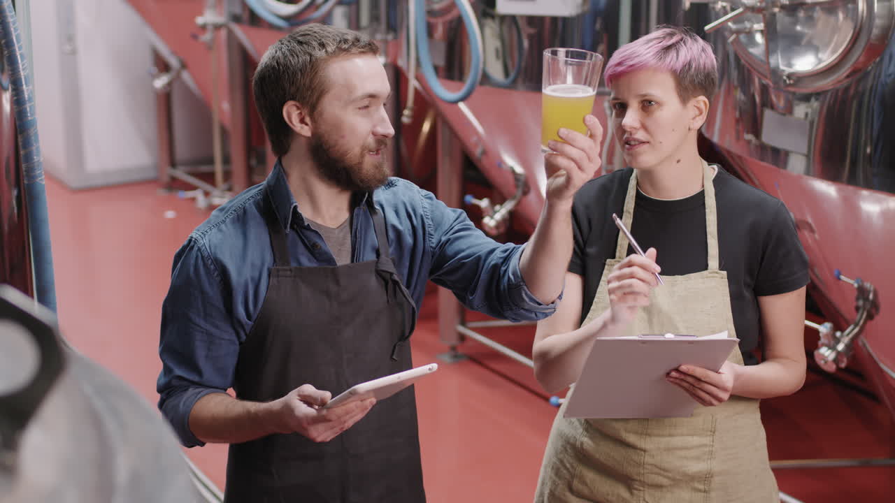 Brewery Workers Checking Beer Sample At Factory
