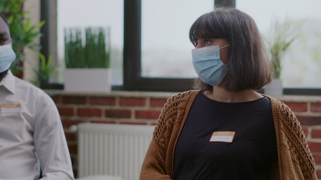 Close up of woman with face mask attending aa group therapy session