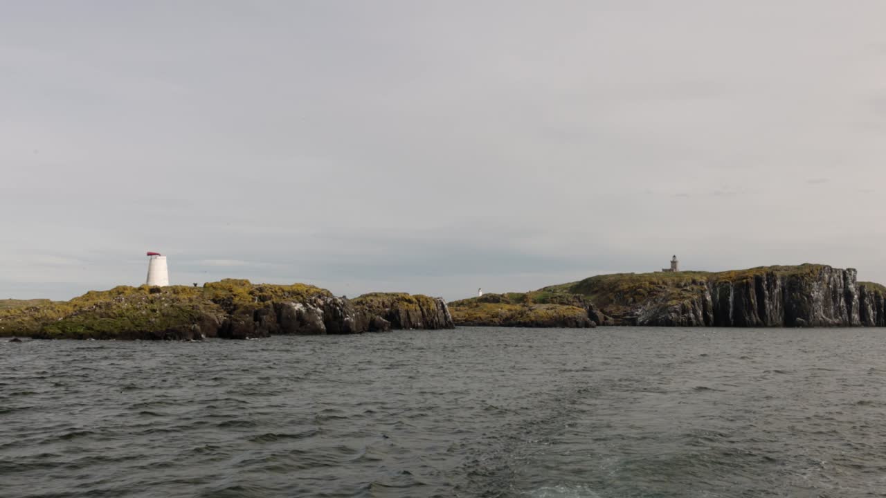 establishing shot of the Isle of May with multiple lighthiuses and foghorns