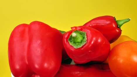 presentación giratoria de verduras frescas frente a una pantalla amarilla en segundo plano