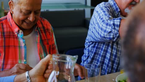 Senior-woman-pouring-juice-into-glass-to-her-friend-4k