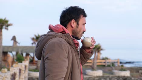 chilean fisherman man drinking mate and looking at the coast of chile moment of calm and relaxation to enjoy his argentine mate in playa duao maule chile