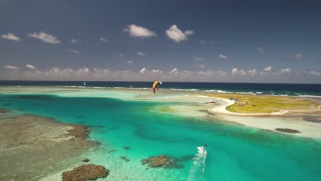 Un-Kitesurfista-Deslizándose-Sobre-Aguas-Cristalinas-Cerca-De-Cayo-Vapor,-Los-Roques,-Venezuela,-Vista-Aérea