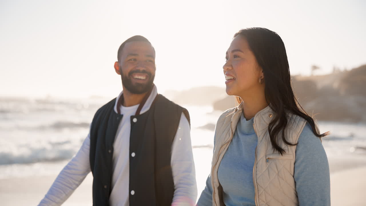pareja, feliz y caminando por una playa al atardecer