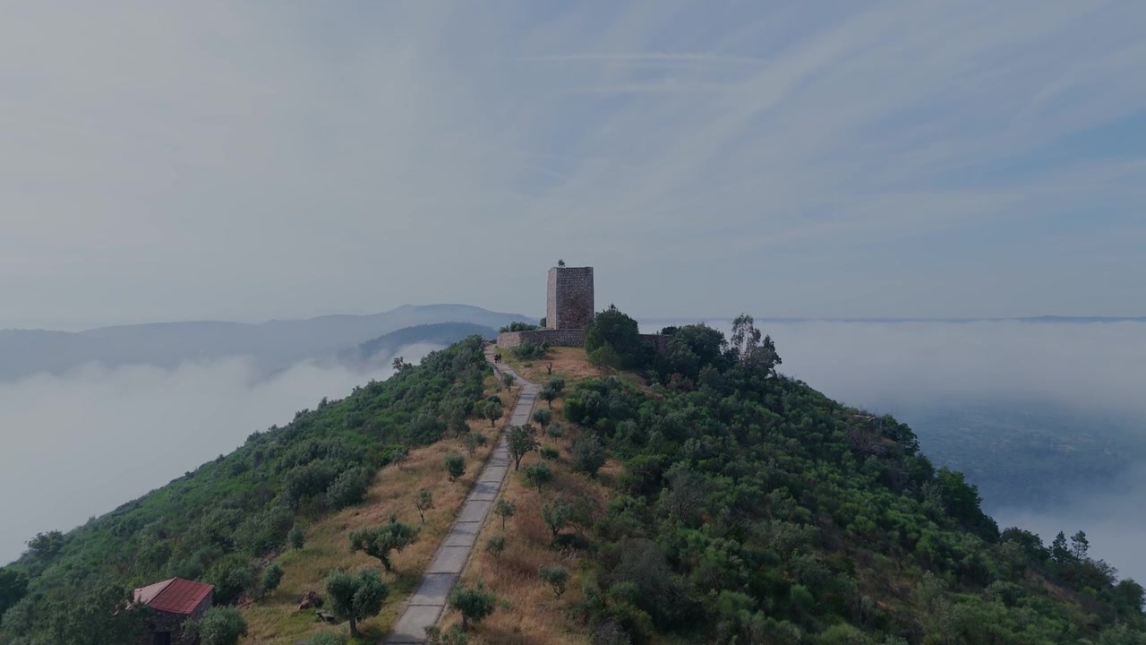 Ripresa orizzontale con drone che si alza sopra il Monumento Naturale Portas do Rodao vicino a Castelo Branco, Portogallo, rivelando la torre del Castelo de Rodao sullo sfondo.