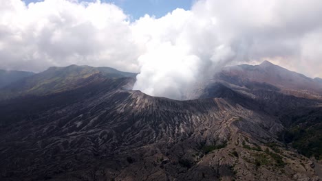 4k-aerial-drone-footage-of-the-dangerous-and-shivering-moment-of-an-eruption,-with-heavy-clouds-above-the-crater-of-the-active-volcano,-Mount-Bromo