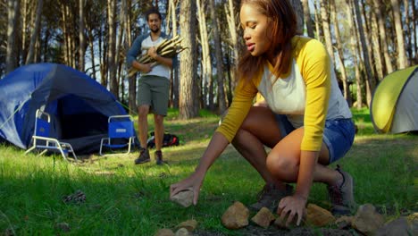 woman preparing bonfire in the forest on a sunny day 4k