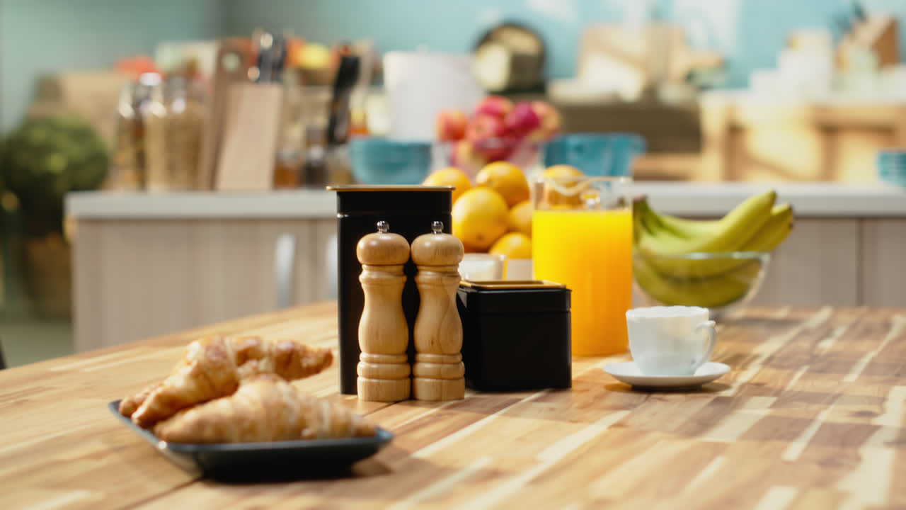 Empty breakfast table in a modern kitchen featuring croissants on plate