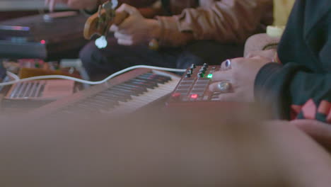 two musicians making music together on a mini keyboard and a bass guitar