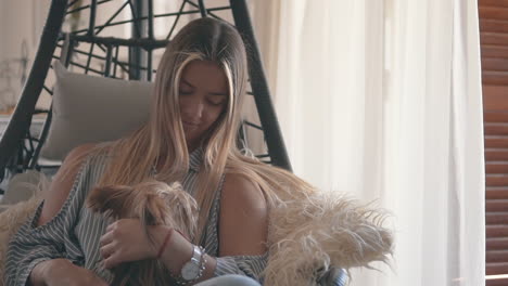 Young-Woman-Petting-Her-Little-Dog-At-Home