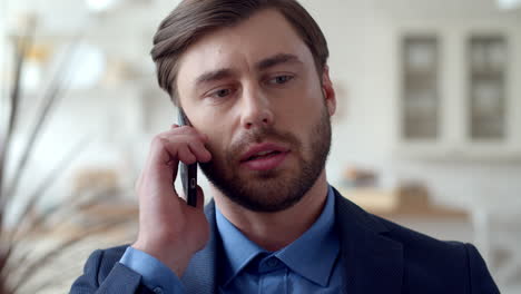 Attractive-business-man-making-phone-call-at-home.-Guy-talking-on-cellphone