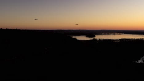 Two-airplanes-descend-towards-Minneapolis-âˆ’-Saint-Paul-International-Airport,-on-a-calm-evening