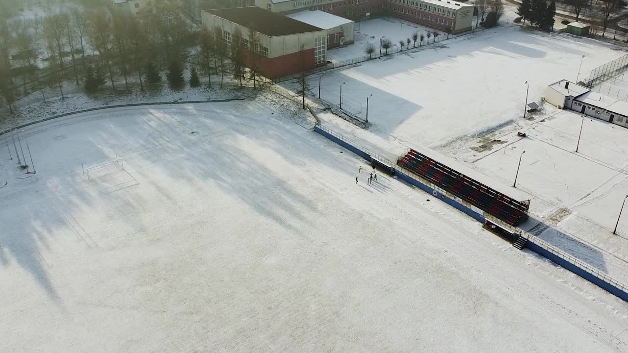 grupo de corredores haciendo ejercicio en una pista nevada, haciendo ejercicio en invierno con un dron