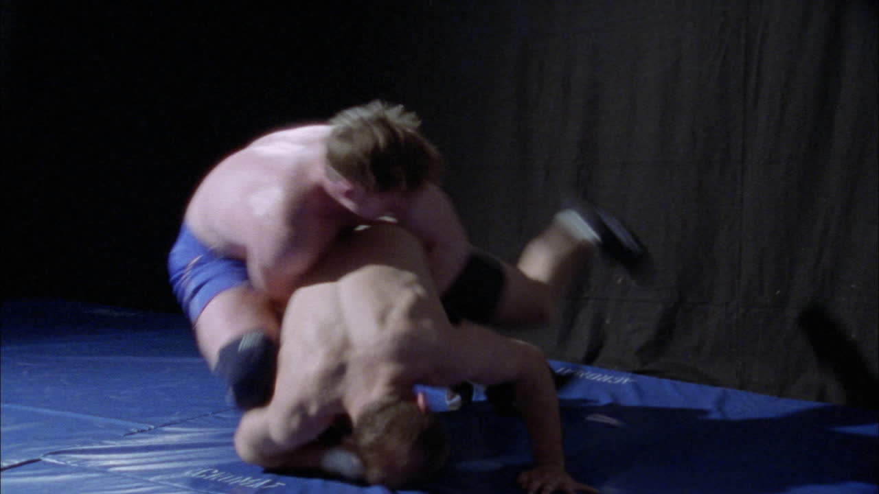 dos atletas están luchando en una colchoneta