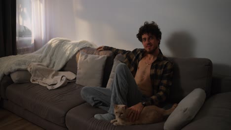 hombre relajándose en el sofá con el gato
