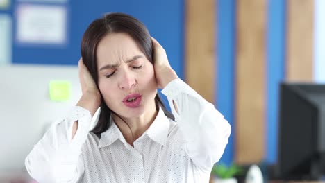 woman covers ears with her hands and shakes head