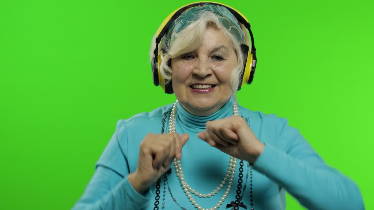 Nonna anziana. Donna caucasica. Balla, festeggia, ascolta musica. Chroma key.