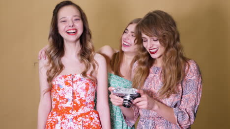 three friends laughing with a vintage camera