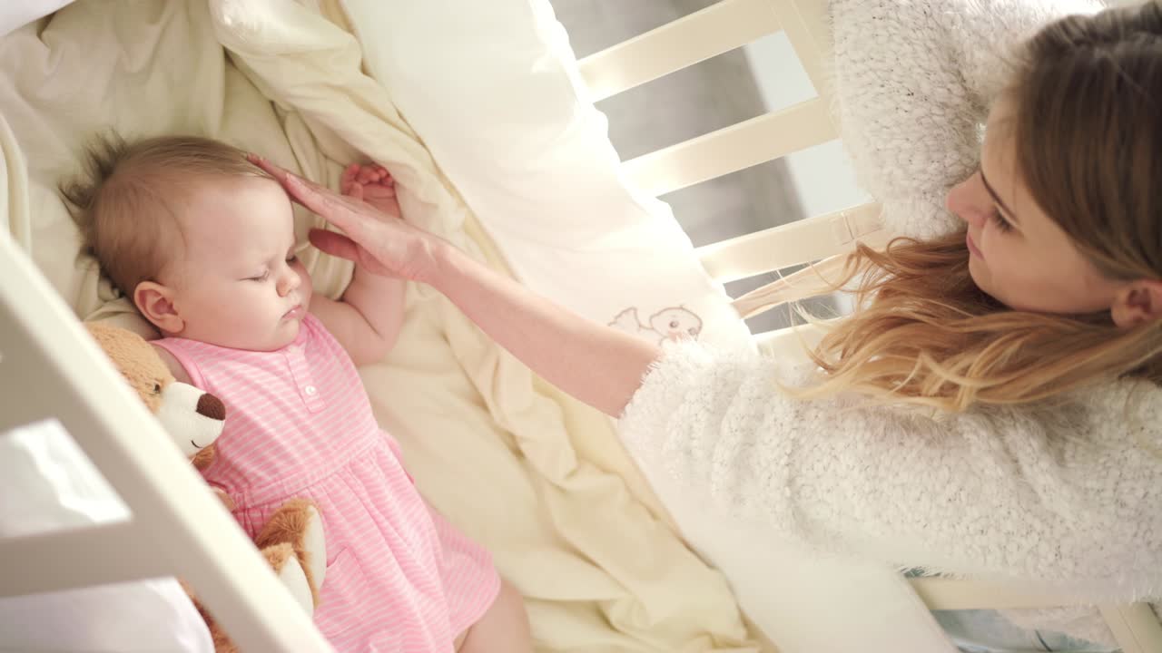 Madre che accarezza il bambino che dorme. Tempo di dolci sogni. Infanzia adorabile