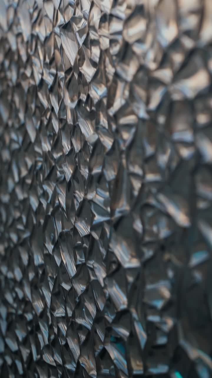 Close-up of textured glass with a mosaic pattern, shot at an oblique angle