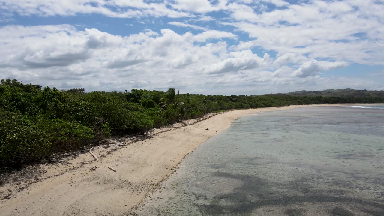 playa de natadola, viti levu: una impresionante vista panorámica revela la extensión de arenas blancas suaves que se encuentran con el mar azul, enmarcada por vegetación verde y palmeras balanceadas