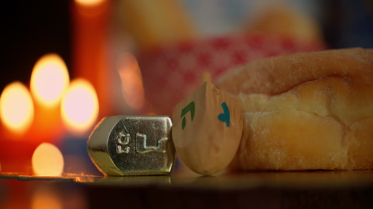 Hanukkah Dreidels and Donut with Festive Candlelight Background