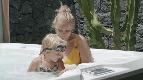 Madre-E-Hija-Pequeña-Relajándose-Y-Divirtiéndose-En-La-Bañera-De-Hidromasaje