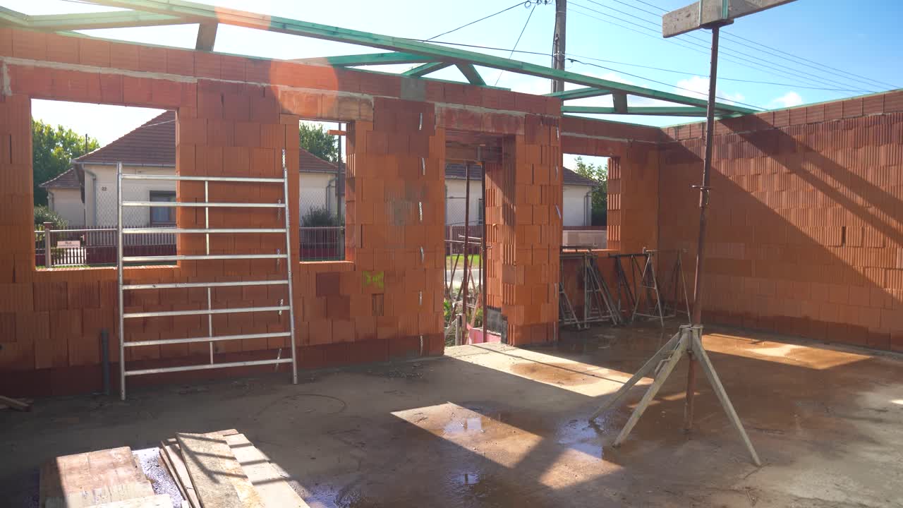 Interior of brick house under construction with open roof beams
