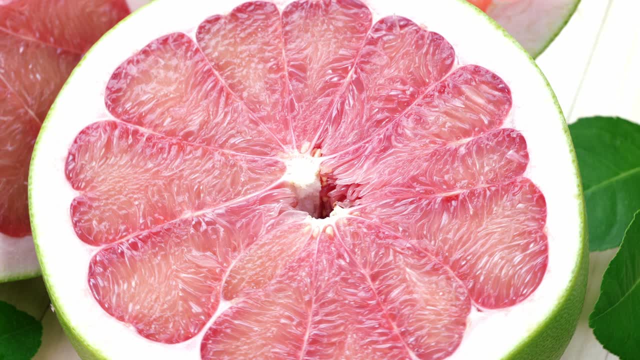 정원에서 나무 테이블에 잎을 가진 빨간 포멜로 과일을 회전, 나무 배경 4k 해상도에서 잎과 함께 빨간 포মেল로 과일.