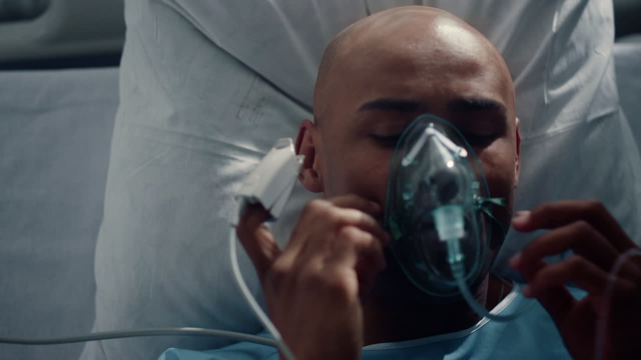 el paciente se pone la máscara de oxígeno acostado en la cama de cerca. oximetro de pulso en el dedo.
