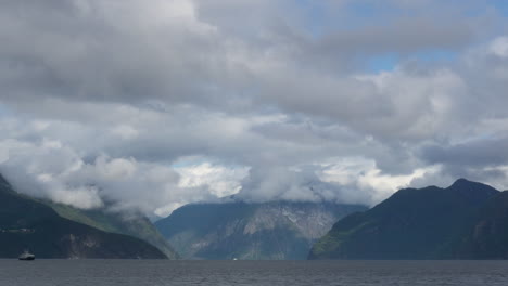 timelapse of a ferry crossing a fjord with busy water and fast-moving clouds