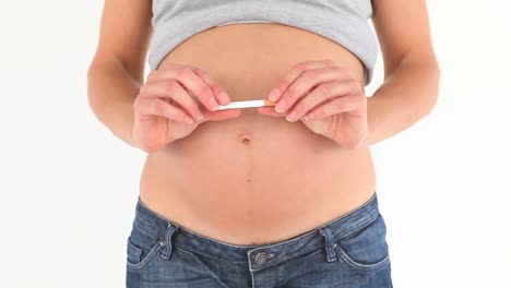 pregnant woman breaking a cigarette