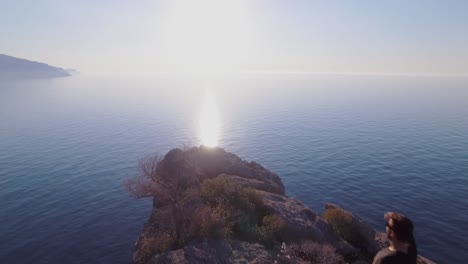 imágenes de drones de 4k de un hombre escalando un acantilado y disfrutando de la vista del océano - disfrutando de la vida - el viajero hace vacaciones - mallorca sa foradada serra de tramuntana