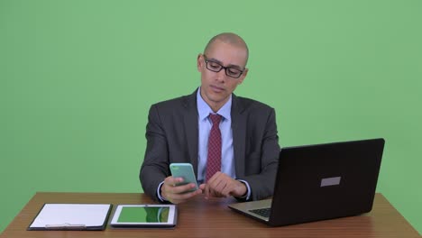 happy handsome bald multi ethnic businessman at office desk