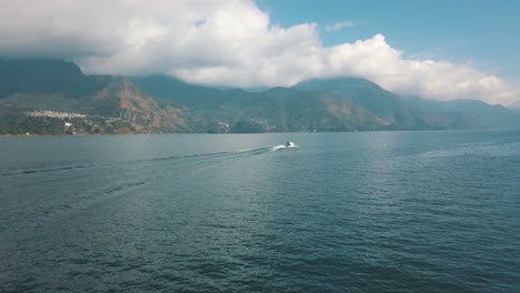 Drone aerial tracking shot of boat driving on lake Atitlan in Guatemala
