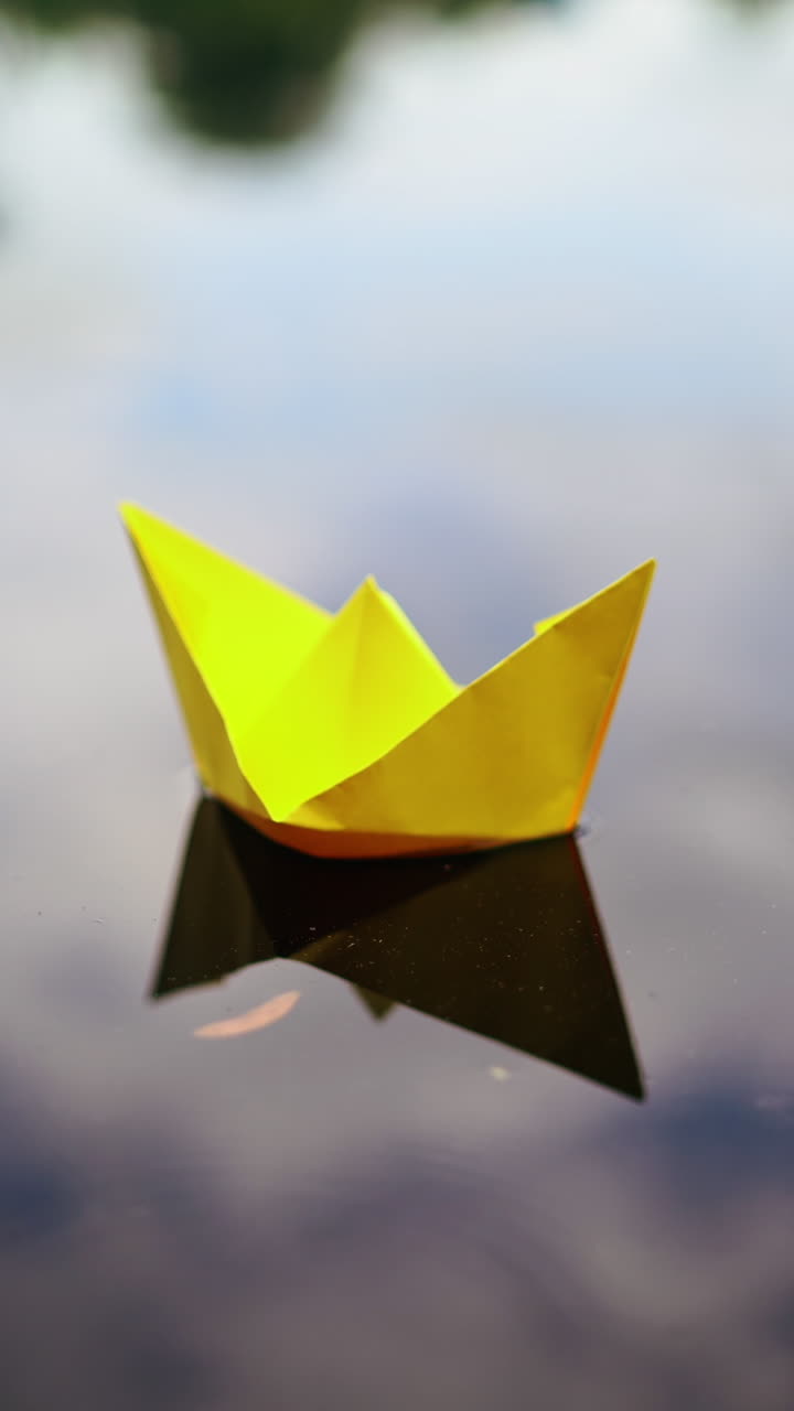 Paper ship in woman hand. Woman putting paper boat into water. Vertical video