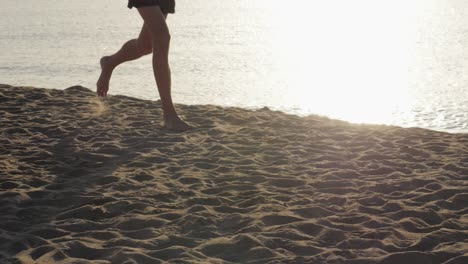 child running barefoot on the beach at sunset