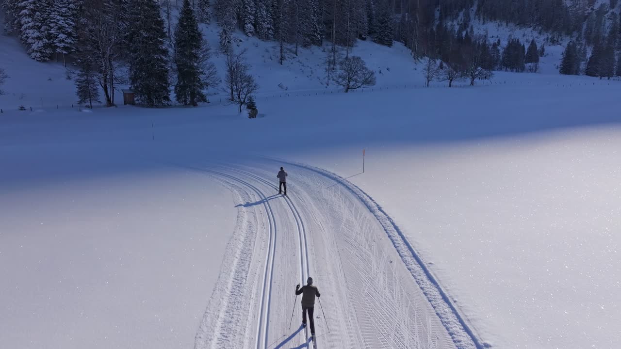 Aerial view of cross-country ski tourers moving over Austria white fields
