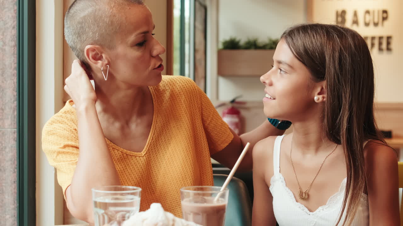 Girl and her mother Enjoy Breakfast at a Cafe