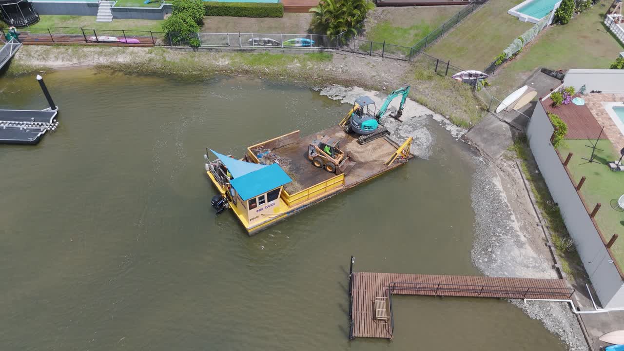 imágenes aéreas de un tractor de limpieza en una barcaza