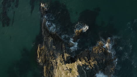 4k top view drone shot of shallow ocean and a lonely island outside byron bay, australia