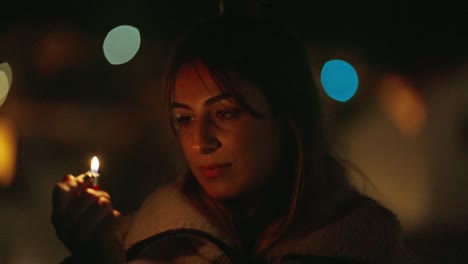 joven vestida con abrigo y cabello abierto, iluminando y mirando fijamente la llama amarilla del encendedor en la oscuridad con luz de neón